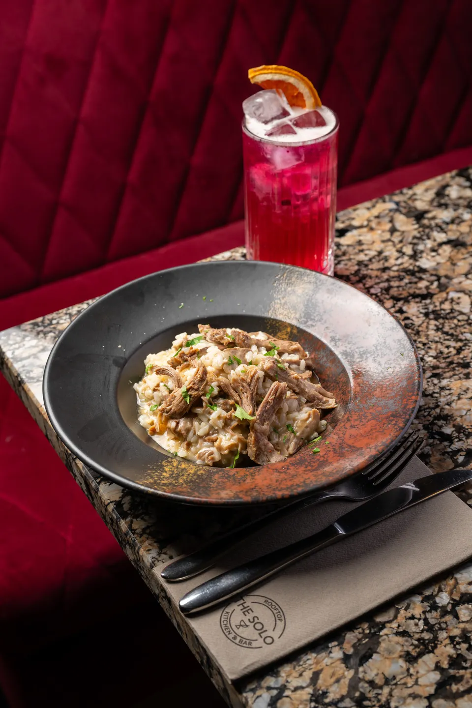 Dinner at TheSolo Kitchen & Bar: slow-cooked lamb risotto and a signature cocktail on the marble table
